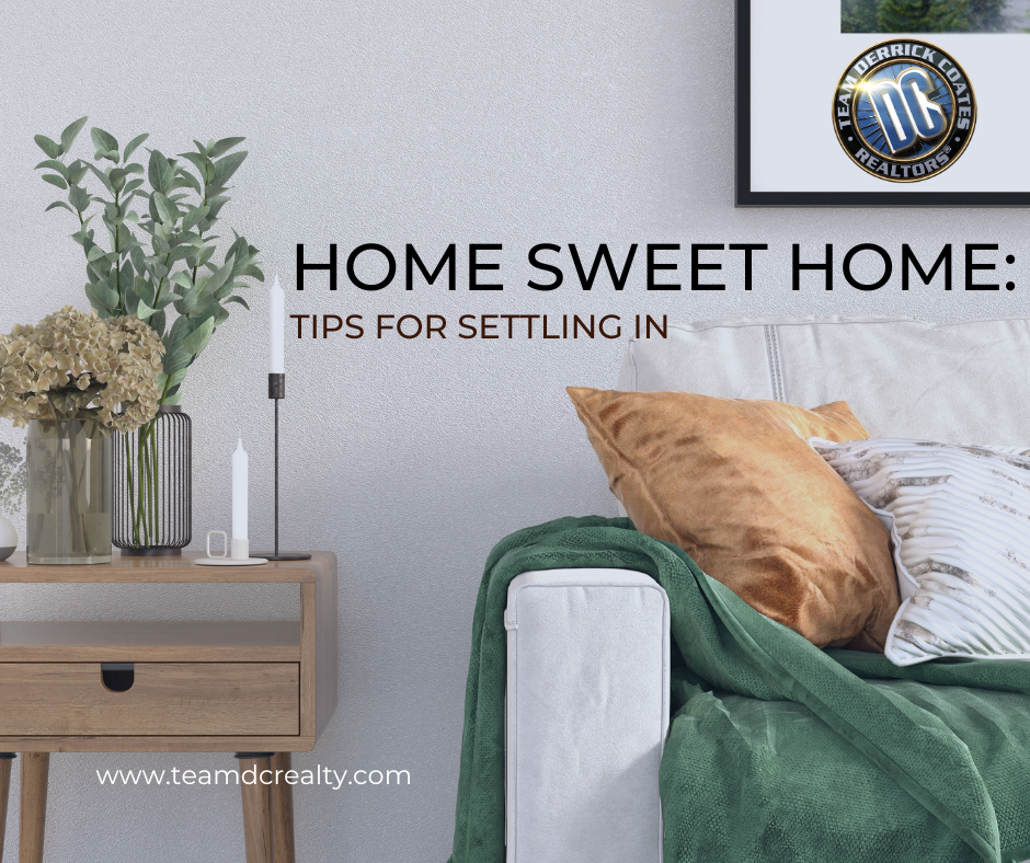 Photo of home interior showing part of a couch and side table with planters, candles and pillows.