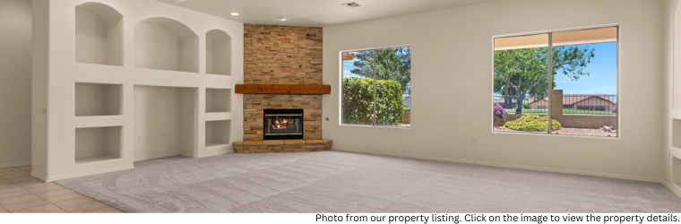 Living room view with built-in entertainment wall next to brick fireplace.