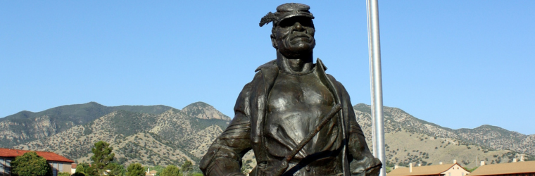 Photo of Buffalo soldier statue with mountains in the background.